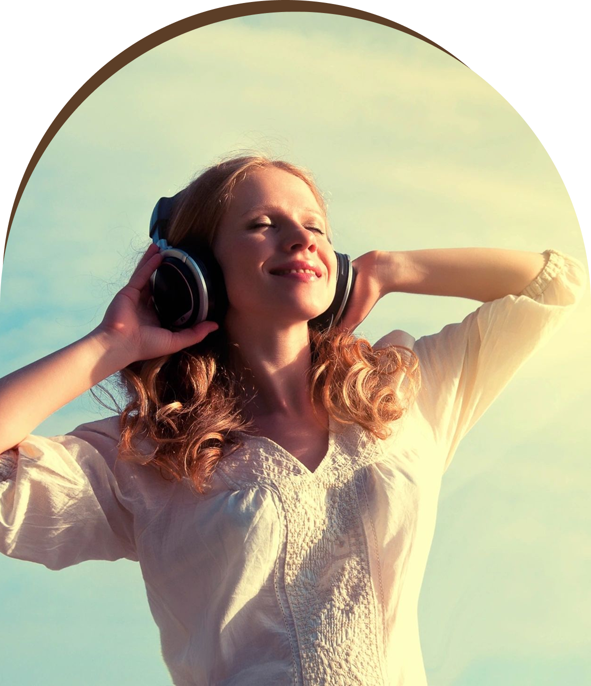 Group 1321317387 A woman with headphones on her ears is smiling.